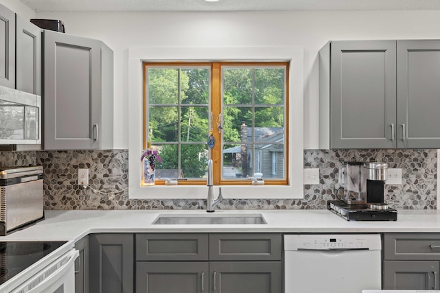 11 Osprey Ln, East Lyme, CT 06357 - kitchen featuring white appliances, gray cabinetry, a sink, light countertops, and backsplash