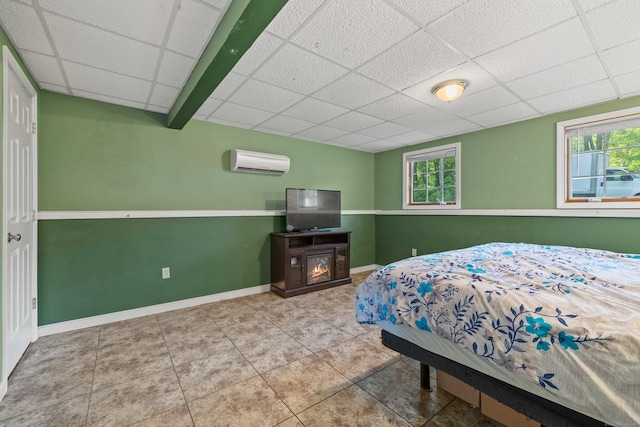 11 Osprey Ln, East Lyme, CT 06357 - bedroom featuring a drop ceiling, an AC wall unit, tile patterned floors, and baseboards