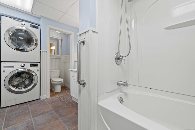 11 Osprey Ln, East Lyme, CT 06357 - full bath with stacked washer / drying machine, toilet, shower / washtub combination, wainscoting, and tile patterned flooring