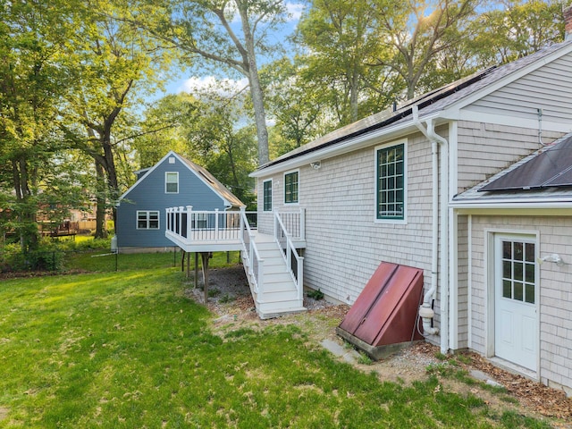 11 Osprey Ln, East Lyme, CT 06357 - back of property featuring a wooden deck, a lawn, stairs, a shingled roof, and view of wooded area