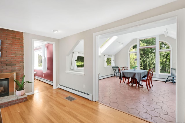 bonus room featuring a baseboard heating unit, healthy amount of natural light, and lofted ceiling