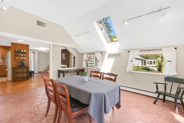 dining area featuring track lighting, stairway, high vaulted ceiling, a skylight, and light tile patterned floors