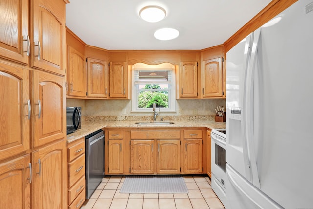 kitchen featuring white appliances, a sink, light tile patterned floors, and light stone countertops