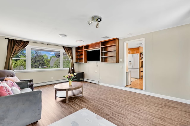 living area featuring baseboard heating, light wood-style flooring, a baseboard heating unit, and baseboards