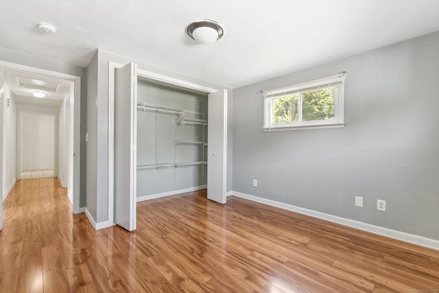 31 Scott St, East Hartford, CT 06118 - unfurnished bedroom featuring a closet, attic access, wood finished floors, and baseboards