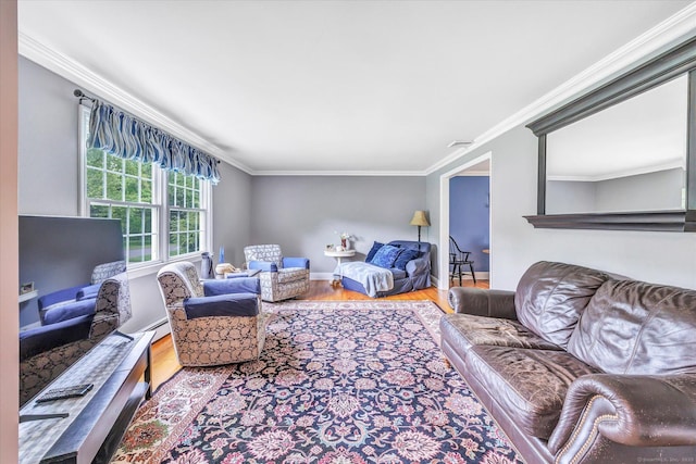 living room featuring wood finished floors, ornamental molding, and baseboards