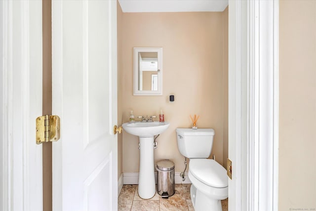 bathroom featuring toilet, baseboards, and tile patterned floors