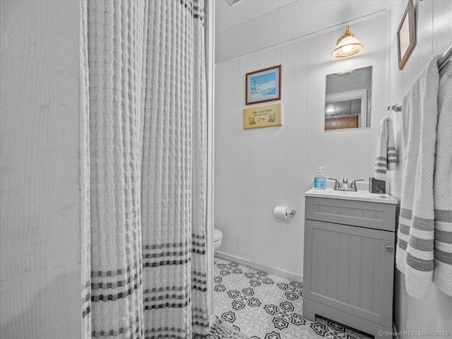 571 Pond Point Ave, Milford, CT 06460 - full bath featuring toilet, vanity, tile patterned flooring, curtained shower, and baseboards