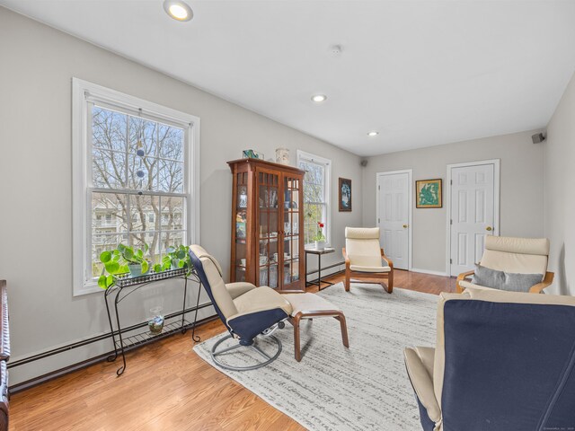 571 Pond Point Ave, Milford, CT 06460 - living area featuring healthy amount of natural light, recessed lighting, wood finished floors, and a baseboard radiator