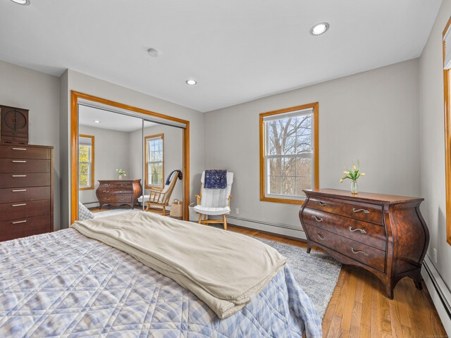 571 Pond Point Ave, Milford, CT 06460 - bedroom featuring a baseboard heating unit, multiple windows, wood finished floors, and recessed lighting