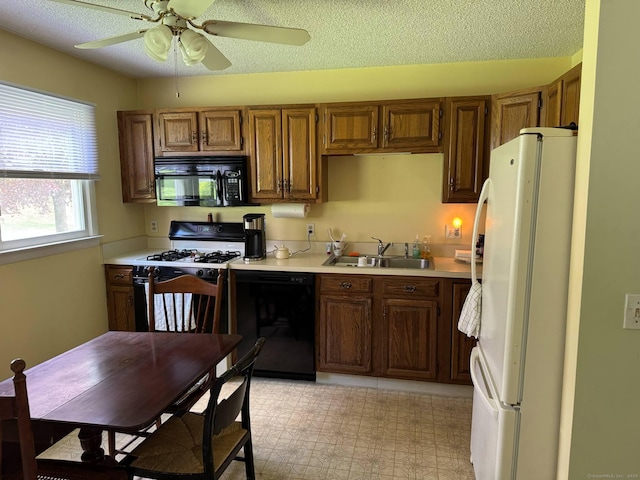 kitchen with black appliances, a sink, light countertops, a ceiling fan, and brown cabinets