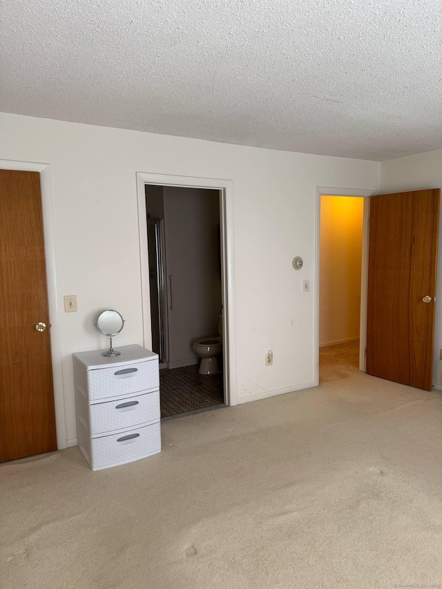 unfurnished bedroom featuring light colored carpet and a textured ceiling
