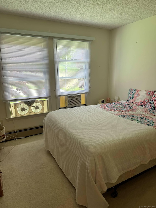 bedroom with carpet flooring, baseboard heating, and a textured ceiling