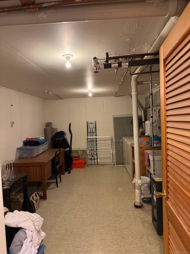 finished basement featuring washing machine and clothes dryer and light floors