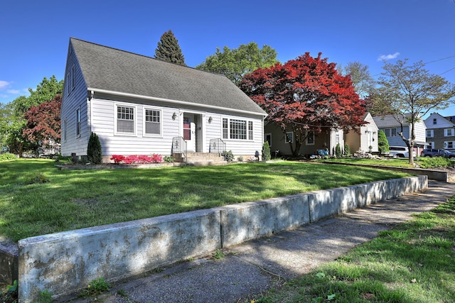 cape cod house with a front lawn and roof with shingles