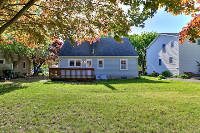 back of house featuring a wooden deck, a lawn, and a shingled roof