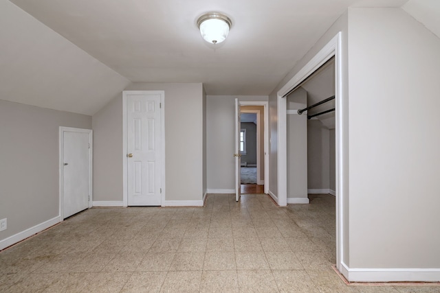 additional living space with lofted ceiling and baseboards