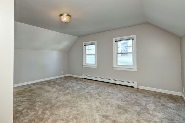 additional living space featuring a baseboard heating unit, lofted ceiling, carpet, and baseboards