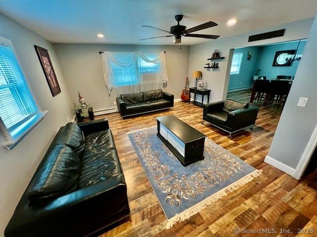 living room with a ceiling fan, wood finished floors, a baseboard radiator, and recessed lighting