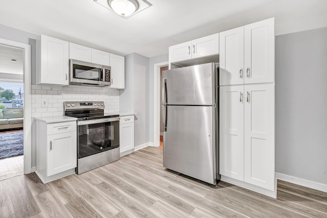 592 Courtland Ave, Bridgeport, CT 06605 - kitchen featuring stainless steel appliances, light countertops, light wood-type flooring, white cabinetry, and baseboards
