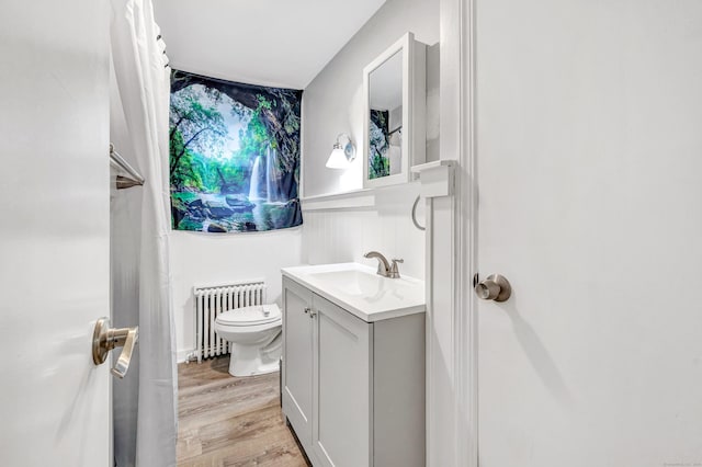 592 Courtland Ave, Bridgeport, CT 06605 - bathroom with radiator, vanity, toilet, and wood finished floors