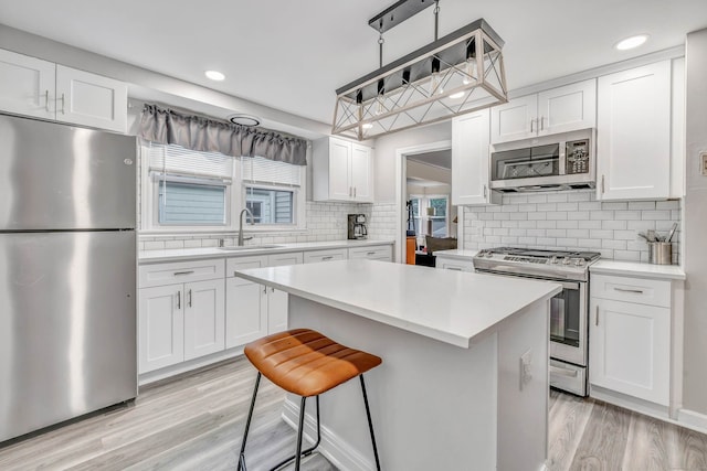 592 Courtland Ave, Bridgeport, CT 06605 - kitchen with appliances with stainless steel finishes, a sink, white cabinets, light countertops, and recessed lighting