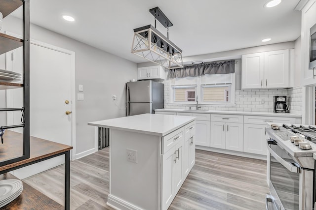592 Courtland Ave, Bridgeport, CT 06605 - kitchen with appliances with stainless steel finishes, a sink, light countertops, white cabinetry, and decorative backsplash