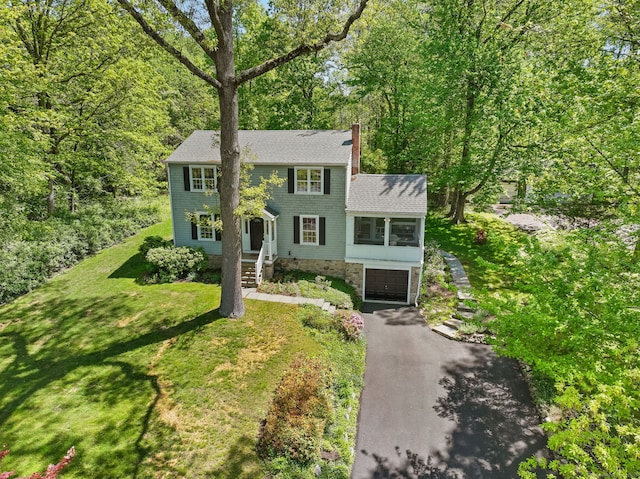 24 Richards Ln, Norwalk, CT 06851 - colonial house featuring asphalt driveway, a garage, a chimney, a shingled roof, and a sunroom