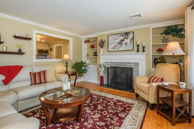121 Dinatali Dr, Waterbury, CT 06705 - living area featuring light wood-style flooring, built in shelves, crown molding, and a fireplace