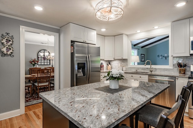 121 Dinatali Dr, Waterbury, CT 06705 - kitchen with stainless steel appliances, a chandelier, a sink, ornamental molding, and light wood-style floors