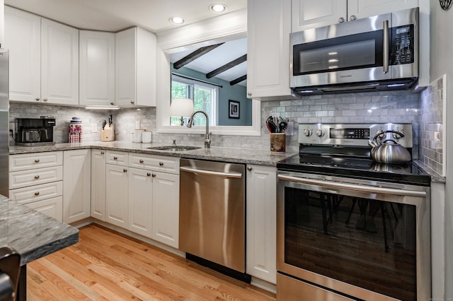 121 Dinatali Dr, Waterbury, CT 06705 - kitchen with appliances with stainless steel finishes, a sink, light wood-type flooring, white cabinets, and recessed lighting