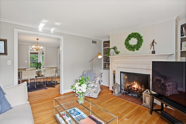 76 Glenbrook Rd, West Hartford, CT 06107 - living area featuring wood finished floors, ornamental molding, a chandelier, and a fireplace with flush hearth