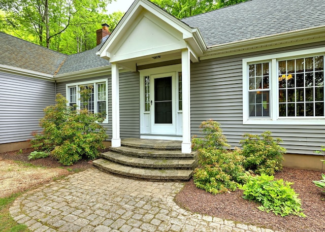 980 Mount Carmel Ave, Hamden, CT 06518 - view of exterior entry featuring a shingled roof and a chimney
