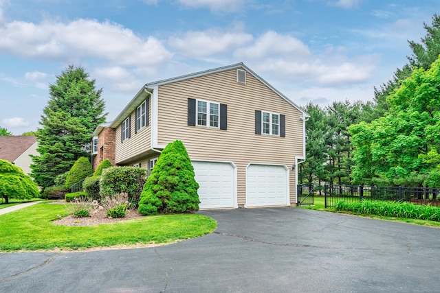 view of side of home featuring an attached garage and driveway