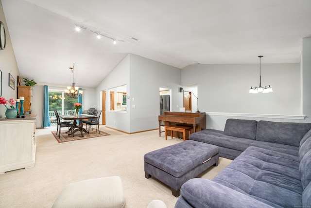 living area with a chandelier, track lighting, lofted ceiling, light carpet, and baseboards