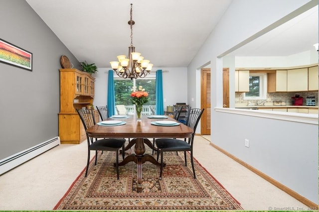 dining space featuring a chandelier, a baseboard heating unit, and light colored carpet