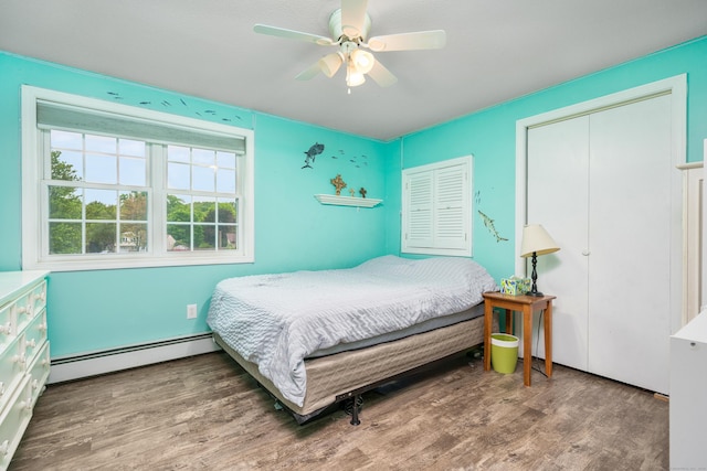 bedroom with a baseboard radiator, wood finished floors, and ceiling fan