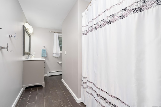bathroom with a baseboard radiator, baseboards, and vanity