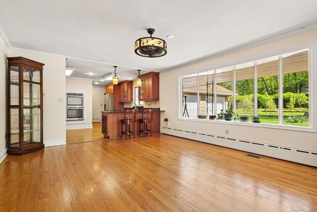 1 Penwood Rd, Bloomfield, CT 06002 - unfurnished living room with ornamental molding, light wood finished floors, a textured ceiling, baseboards, and a baseboard heating unit