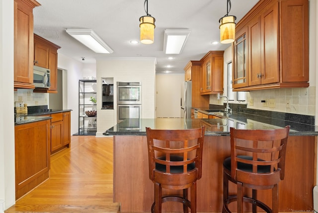 1 Penwood Rd, Bloomfield, CT 06002 - kitchen featuring stainless steel appliances, brown cabinetry, a peninsula, glass insert cabinets, and a sink