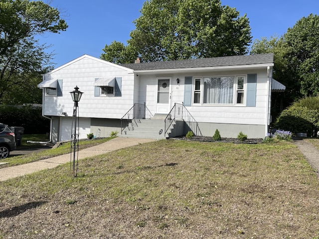 view of front of home with a front lawn, an attached garage, and a chimney