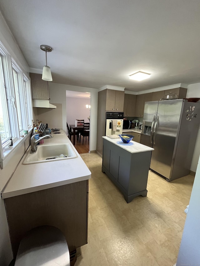 kitchen featuring a sink, white appliances, light countertops, and a kitchen island