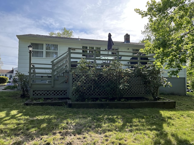 back of house with a yard, a deck, a chimney, and stairway