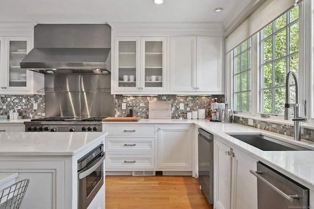 144 S Ave, New Canaan, CT 06840 - kitchen featuring wall chimney exhaust hood, a sink, stainless steel appliances, white cabinetry, and recessed lighting
