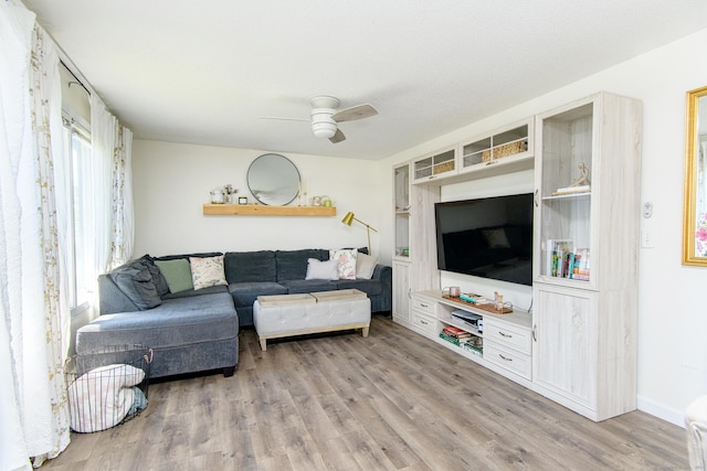 living area featuring ceiling fan, wood finished floors, and baseboards