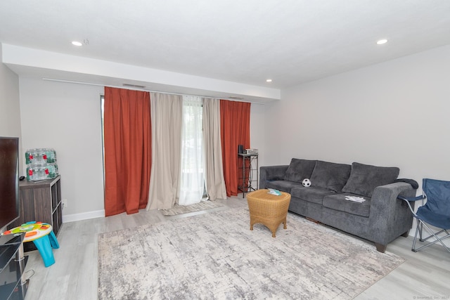 living area with wood finished floors, recessed lighting, and baseboards