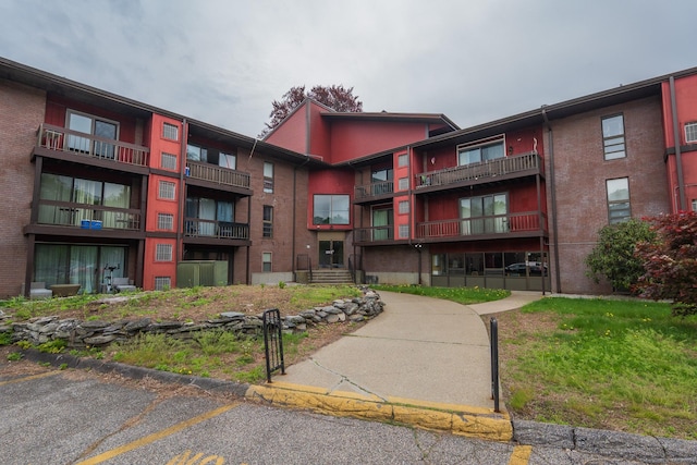 view of apartment building / complex featuring uncovered parking