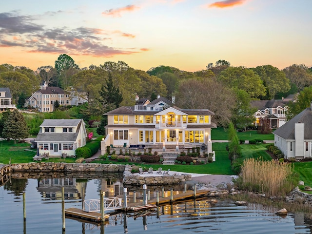 52 Old N Rd, Stonington, CT 06355 - back of house at dusk featuring a water view, a balcony, a lawn, and a patio