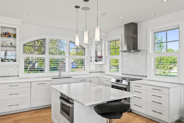 52 Old N Rd, Stonington, CT 06355 - kitchen featuring wall chimney exhaust hood, a sink, light stone counters, appliances with stainless steel finishes, and tasteful backsplash