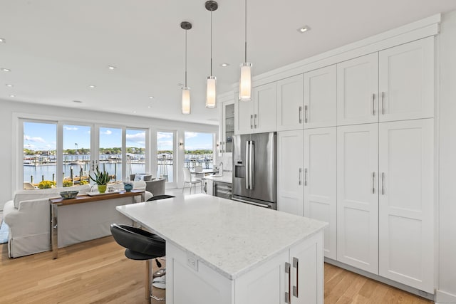 52 Old N Rd, Stonington, CT 06355 - kitchen with stainless steel fridge, light wood-style flooring, a center island, light stone countertops, and recessed lighting